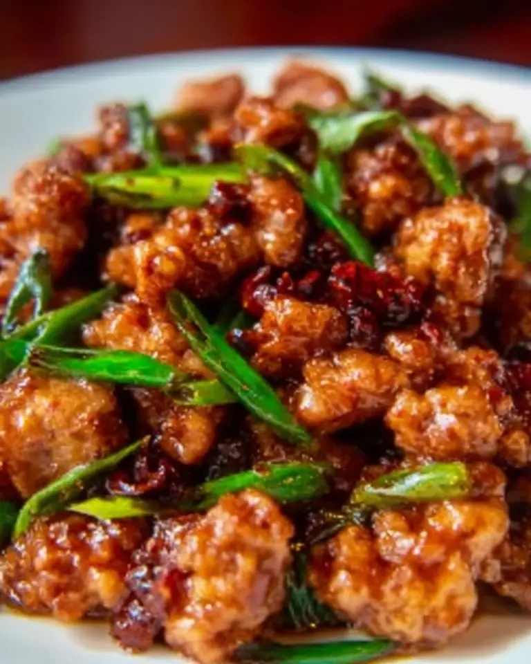 Ground orange chicken dish served with rice and vegetables
