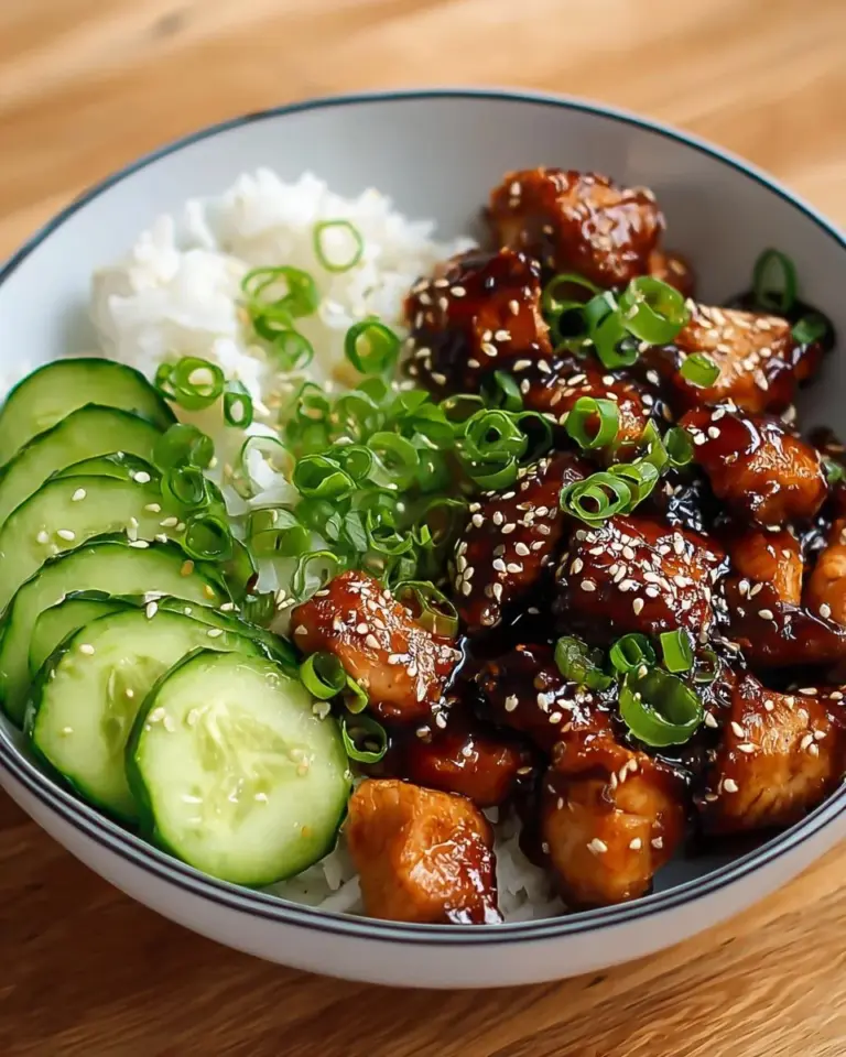 Sticky Honey Gochujang Chicken garnished with sesame seeds and green onions