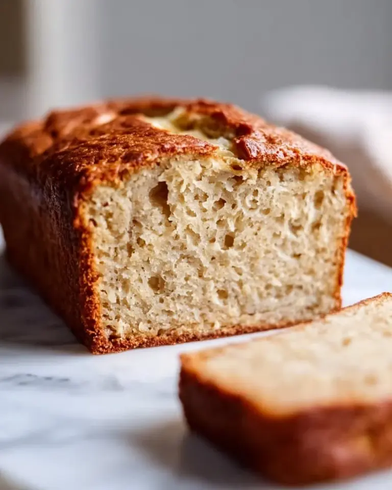 Slice of banana bread made with almond flour, topped with walnuts and banana slices