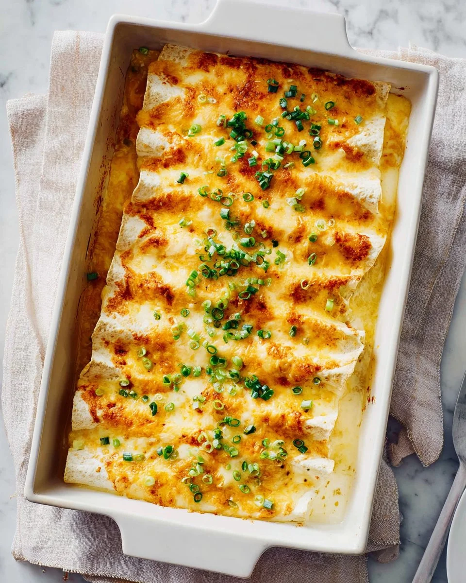 Cheesy chicken enchiladas with white sauce on a plate ready to serve
