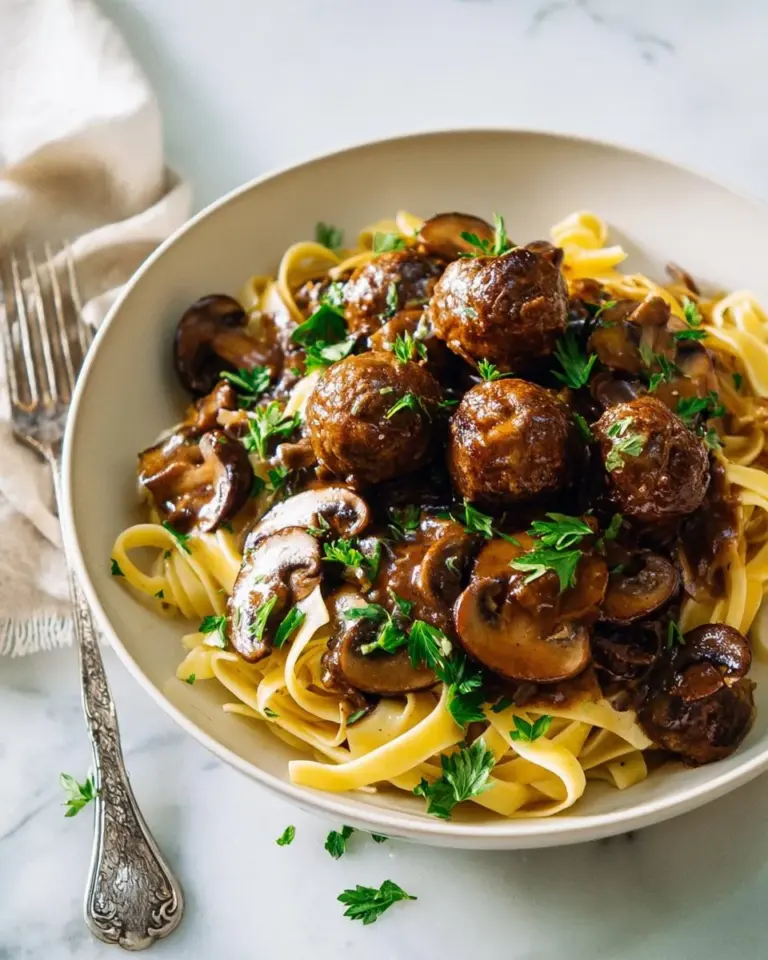 Creamy mushroom pappardelle topped with fresh herbs and cheese