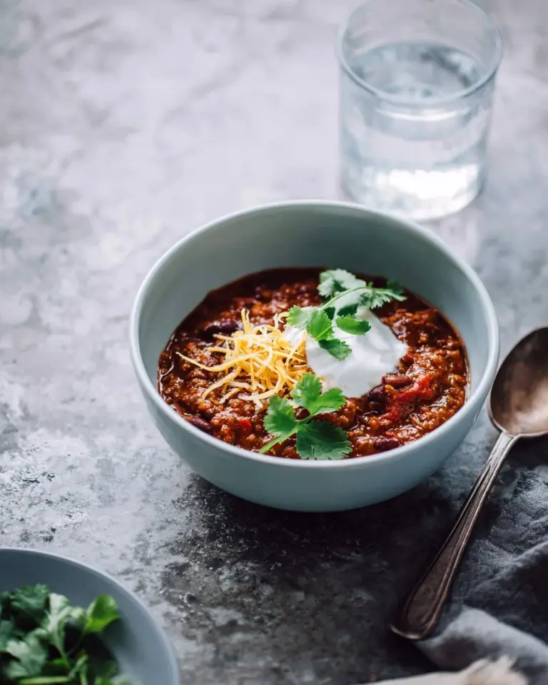 Bowl of Instant Pot Chicken Chili with toppings like cilantro and cheese