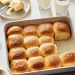 Freshly baked Parker House Rolls on a wooden table