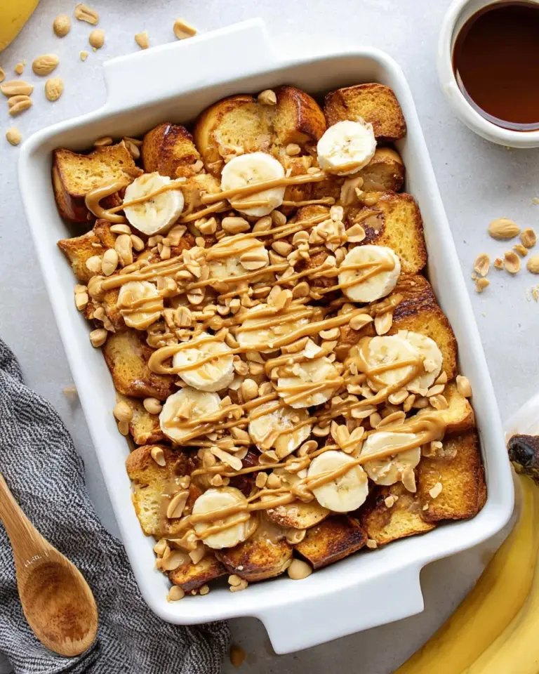 Peanut Butter Banana Overnight French Toast topped with syrup and sliced bananas.