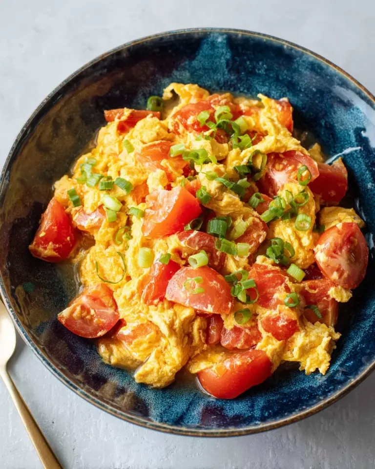 Scrambled eggs with tomatoes served on jasmine rice for a delicious meal.