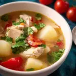 Bowl of Thai Chicken Soup with potatoes and fresh herbs