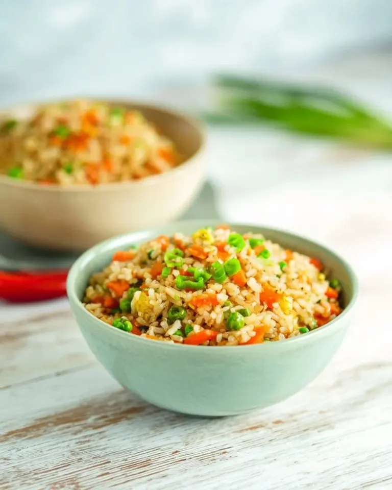 Dish of Thai Garlic Fried Rice garnished with herbs and garlic